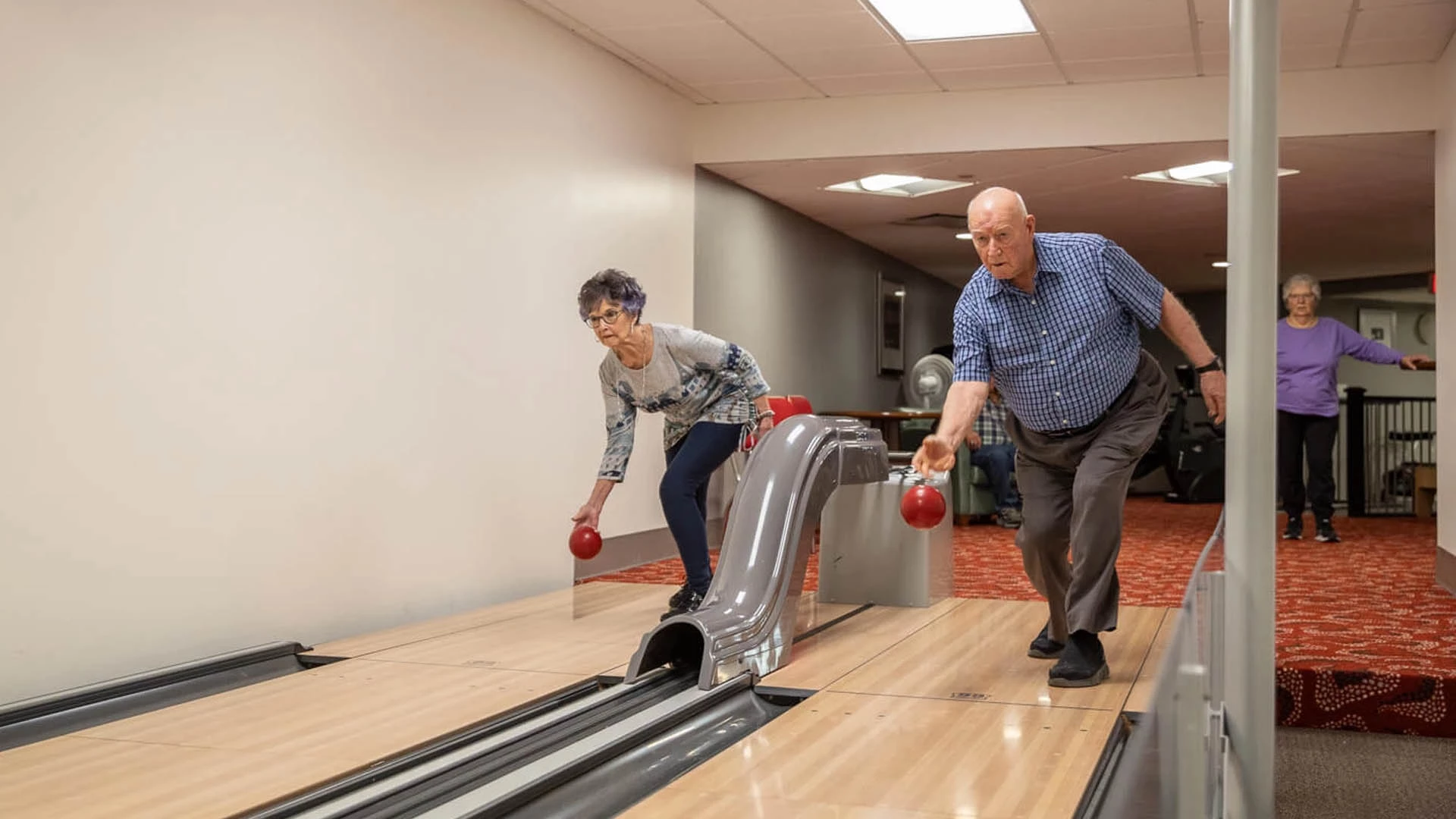 Two seniors bowling at the same time