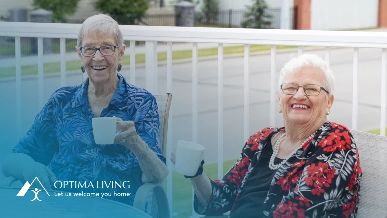 Two senior women drinking coffee at a patio table